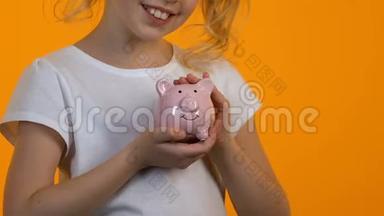 小女孩抚摸储蓄罐，<strong>个人</strong>储蓄和预算，<strong>规划未来</strong>